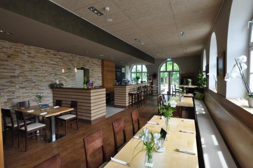 a restaurant with wooden tables and chairs and a brick wall at Volkspark in Bamberg