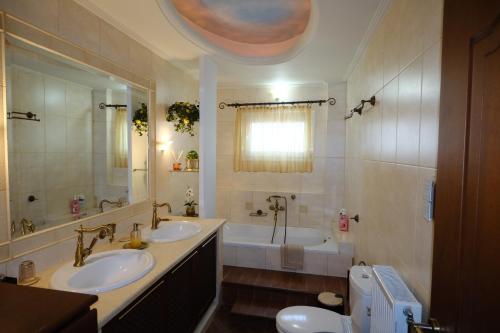 a bathroom with two sinks and a bath tub at La maison de Catherine in Volos