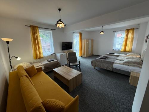 a living room with a couch and a bed at Centrum Noclegi in Krynica Zdrój