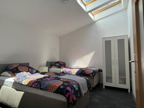 two beds in a room with a room with windows at Modern apartment with space for 6 in Weißenfels