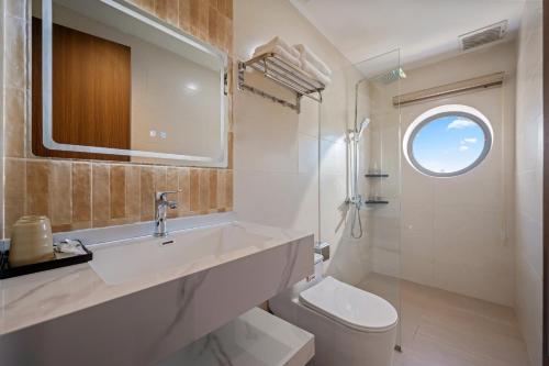 a bathroom with a sink and a toilet and a window at RubyHome in Thôn Nguyệt Biều