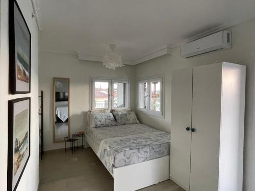a bedroom with a bed in a room with windows at Epanomi SunSet Loft in Epanomi