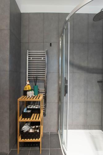 a bathroom with a shower and a shelf with bottles at Azure Residence Koumitsa in Nea Roda