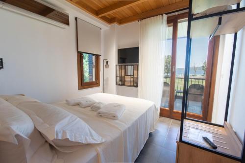 a bedroom with a white bed with towels on it at Azure Residence Koumitsa in Nea Roda