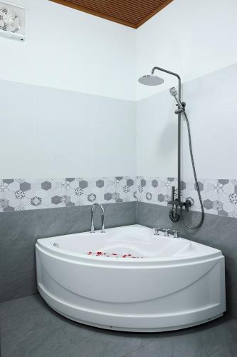 a white bath tub in a bathroom with a wall at Phố Núi 2 Hotel in Pleiku