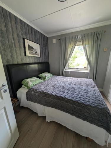 a bedroom with a large bed with a window at Hindås stuga in Hindås