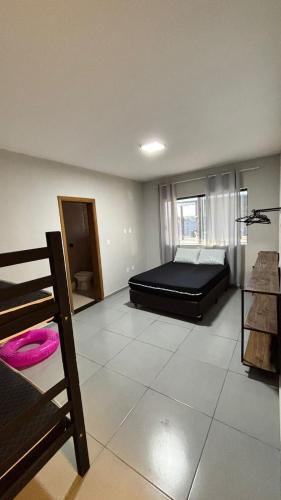 a large room with a bed and a window at Chácara pôr do sol in Araçoiaba da Serra