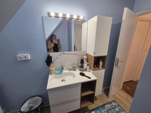 a person taking a picture of a bathroom with a sink at Ti a mor in Carnac