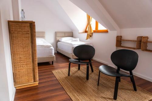 two chairs in a room with a bed and a mirror at Nidum - Šariš Park Hotel & Wellness in Prešov