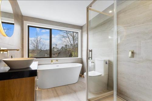 a bathroom with a tub and a sink and a shower at Amore Manor Auckland in Auckland