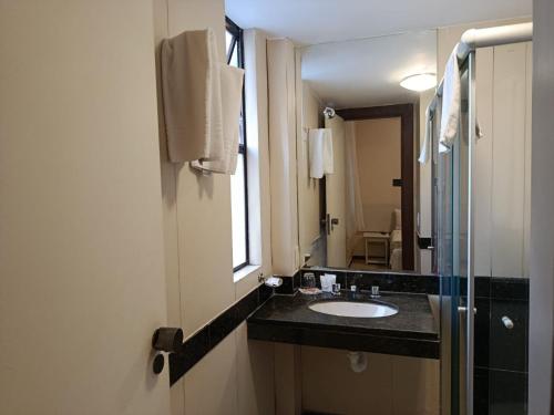 a bathroom with a sink and a mirror at Boulevard Express in Belo Horizonte