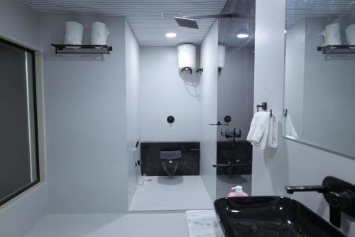 a white bathroom with a toilet and a sink at Hotel Ashok Vatika in Māharjhari