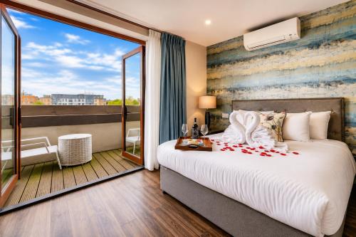 a bedroom with a large bed and a balcony at Villare Hotel Leicester City Centre in Leicester
