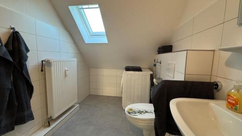 a bathroom with a toilet and a sink and a skylight at Urban Style trifft Heideflair in Schneverdingen