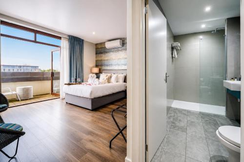 a bedroom with a bed and a bathroom at Villare Hotel Leicester City Centre in Leicester