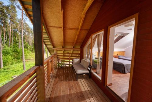 a wrap around porch of a house with a bedroom at Taevaskoja Holiday Center in Taevaskoja