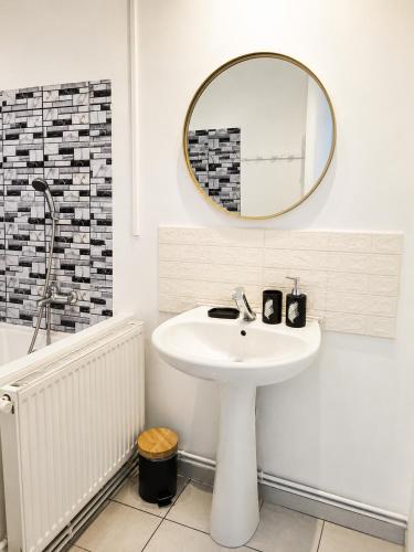 a white bathroom with a sink and a mirror at Maisonnette en duplex avec Jardin-Babyfoot et Billard in Outreau