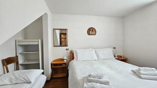 a bedroom with a large white bed and a table at Belvedere Pecol in Mareson