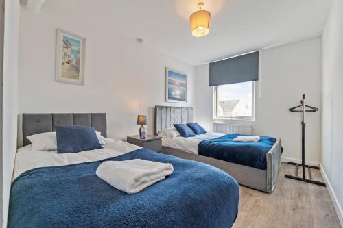 a bedroom with two beds with blue blankets at Executive 4Bedroom Sleeps 9 City Centre Nearby in Parkside