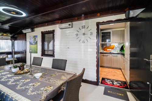 a dining room with a table and a clock on the wall at Urška's Premium House Terme Čatež in Brežice