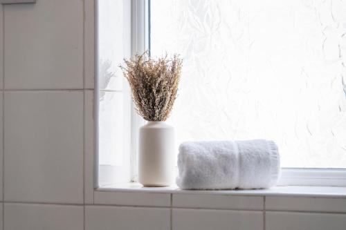 a window sill with a white vase with a towel at Executive 4Bedroom Sleeps 9 City Centre Nearby in Parkside