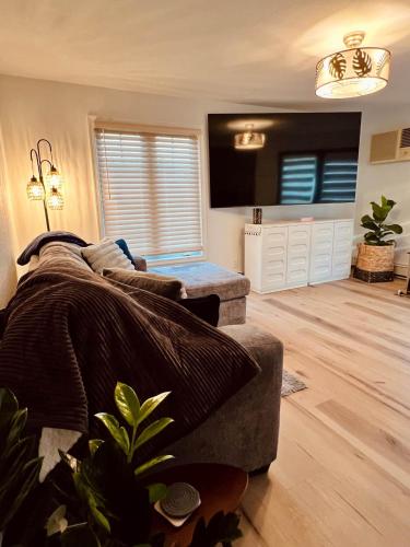 a living room with a couch and a flat screen tv at The SeveraLena, your Tawas Point destination! in East Tawas