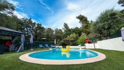 a swimming pool with a rubber duck in a yard at Villa Caraïbes in Vence