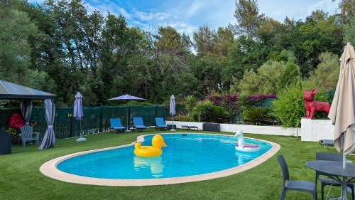 a swimming pool with a rubber duck in a yard at Villa Caraïbes in Vence