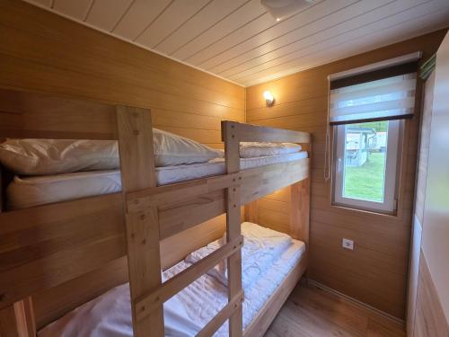 two bunk beds in a cabin with a window at Bungalow Seedorf 9 in Basedow