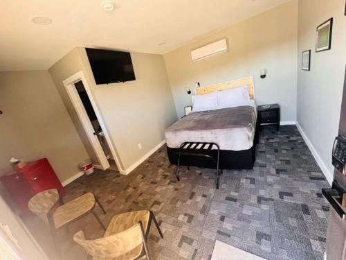 a hotel room with a bed and a tv at Skyliner Motel in Stroud