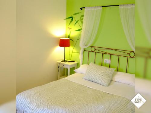 a bedroom with a bed with a red lamp on a table at Hostal Five Gates in Osuna