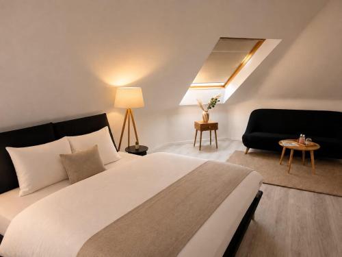 a bedroom with a large white bed and a couch at Hotel zur Linde in Berghausen