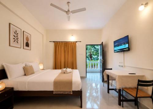 a bedroom with a bed and a table and a window at Coutinho Guest House in Panaji
