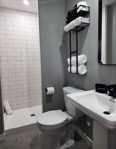 a bathroom with a toilet and a sink and a tub at Skyliner Motel in Stroud