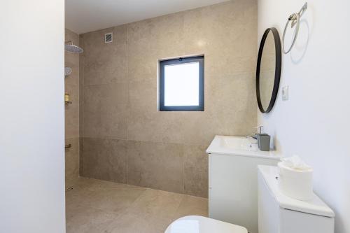 a bathroom with a toilet and a sink and a mirror at Vivenda Vilhegas in Albufeira