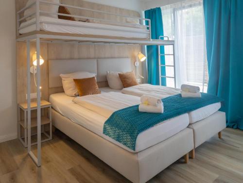 a bedroom with two bunk beds with blue curtains at Fairschlafen Boutique Hotel in Neustadt in Holstein