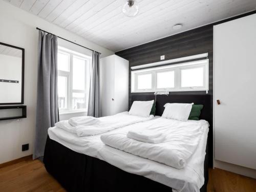 a large bed in a room with two windows at Spacious Slopeside Home with Sauna in Åre