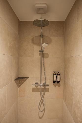 a shower with a shower head in a bathroom at La Chapelle in Annecy