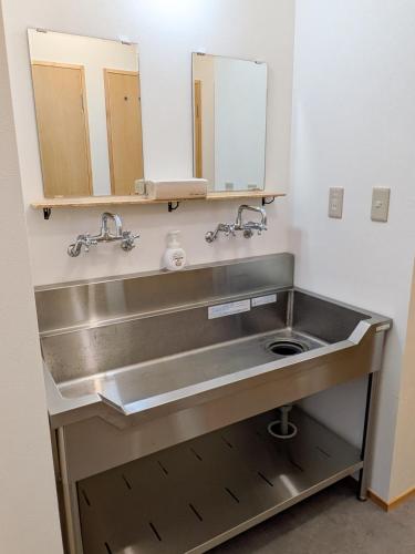 a bathroom with a sink and two mirrors at おかえりヒュッテ in Komagane