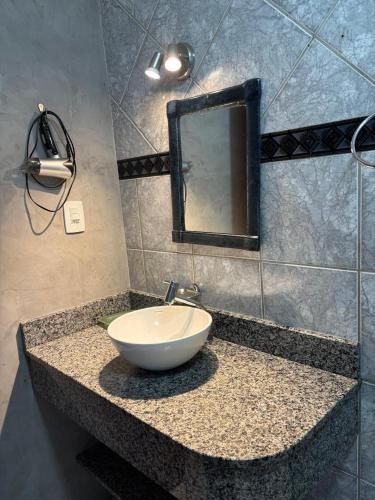 a bathroom with a bowl sink and a mirror at Hospedaria Gãstehaus Enzian in Treze Tílias