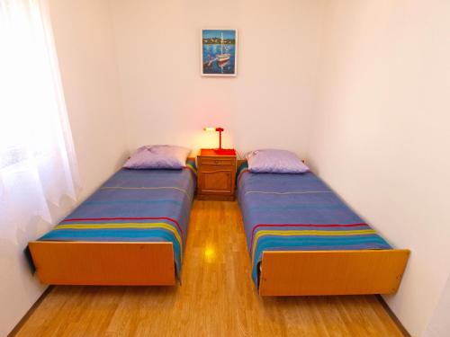 2 łóżka pojedyncze w pokoju ze stolikiem. w obiekcie Apartments Biskupije 940 w Medulinie