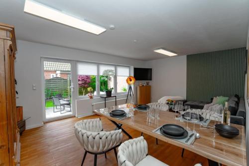 a dining room and living room with a table and chairs at App Ankerplatz in Morsum
