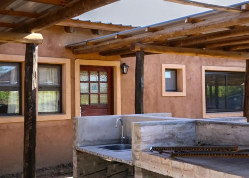 an outdoor kitchen with a sink in front of a house at Terrazas de Lobos in Lobos