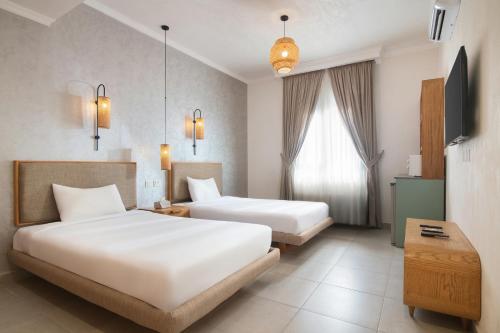 a hotel room with two beds and a window at The Avenue in El Alamein