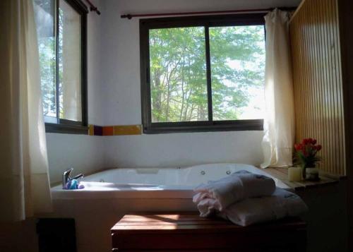 a bathroom with a bath tub and two windows at Terrazas de Lobos in Lobos