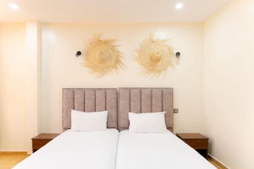 two baskets hanging above a bed in a bedroom at Hola Rio in Dakhla