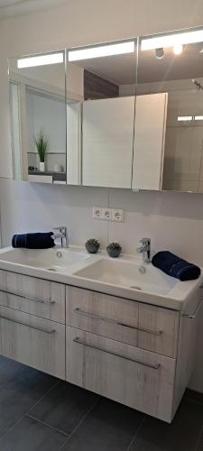 a bathroom with two sinks and a large mirror at Ferienwohnung Am Stadttor in Tann