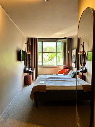 a bedroom with a large bed and a large window at Spar Hotel Majorna in Gothenburg