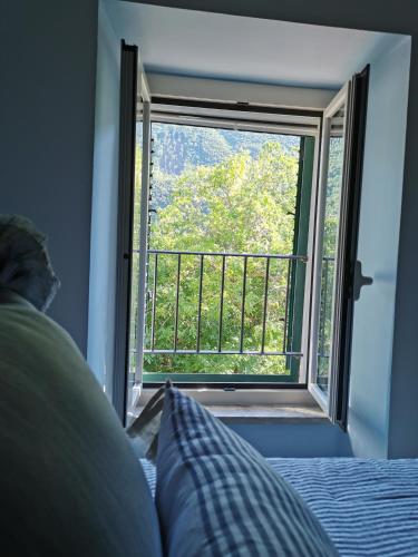 a bedroom with a bed and a window with a view at B&B Il Merlino in Chiaserna