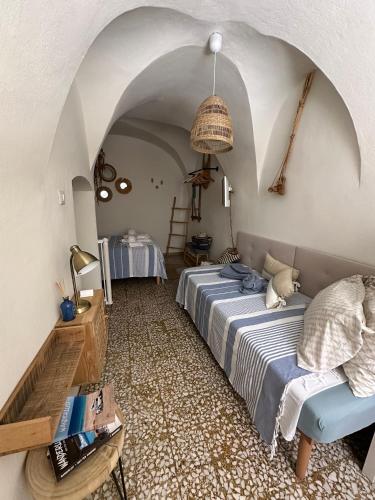 a bedroom with a bed and a table in a room at DOMMO ASULETTA in Bosa